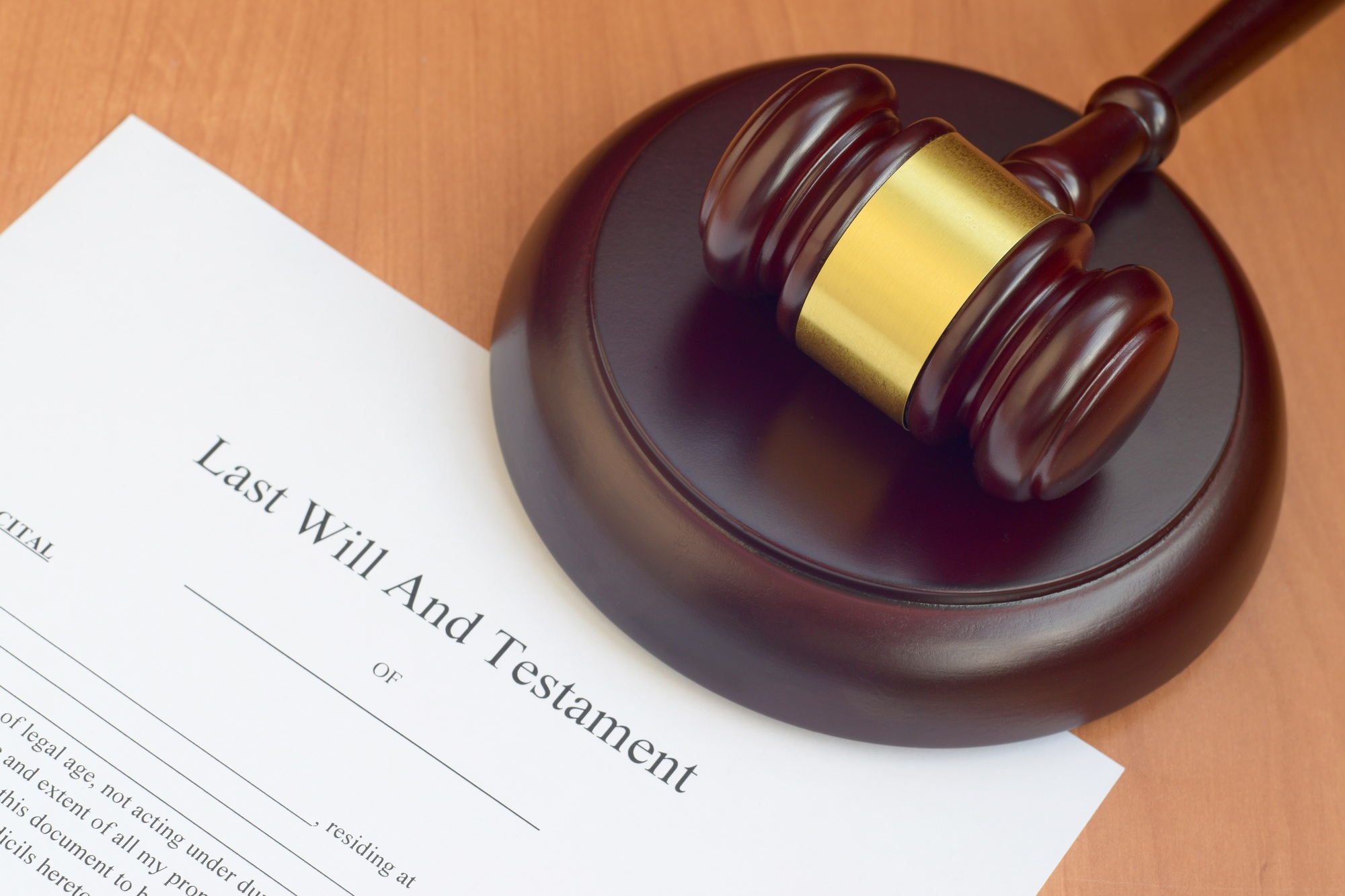 Justice mallet and Last Will and Testament blank document on wooden court table close up