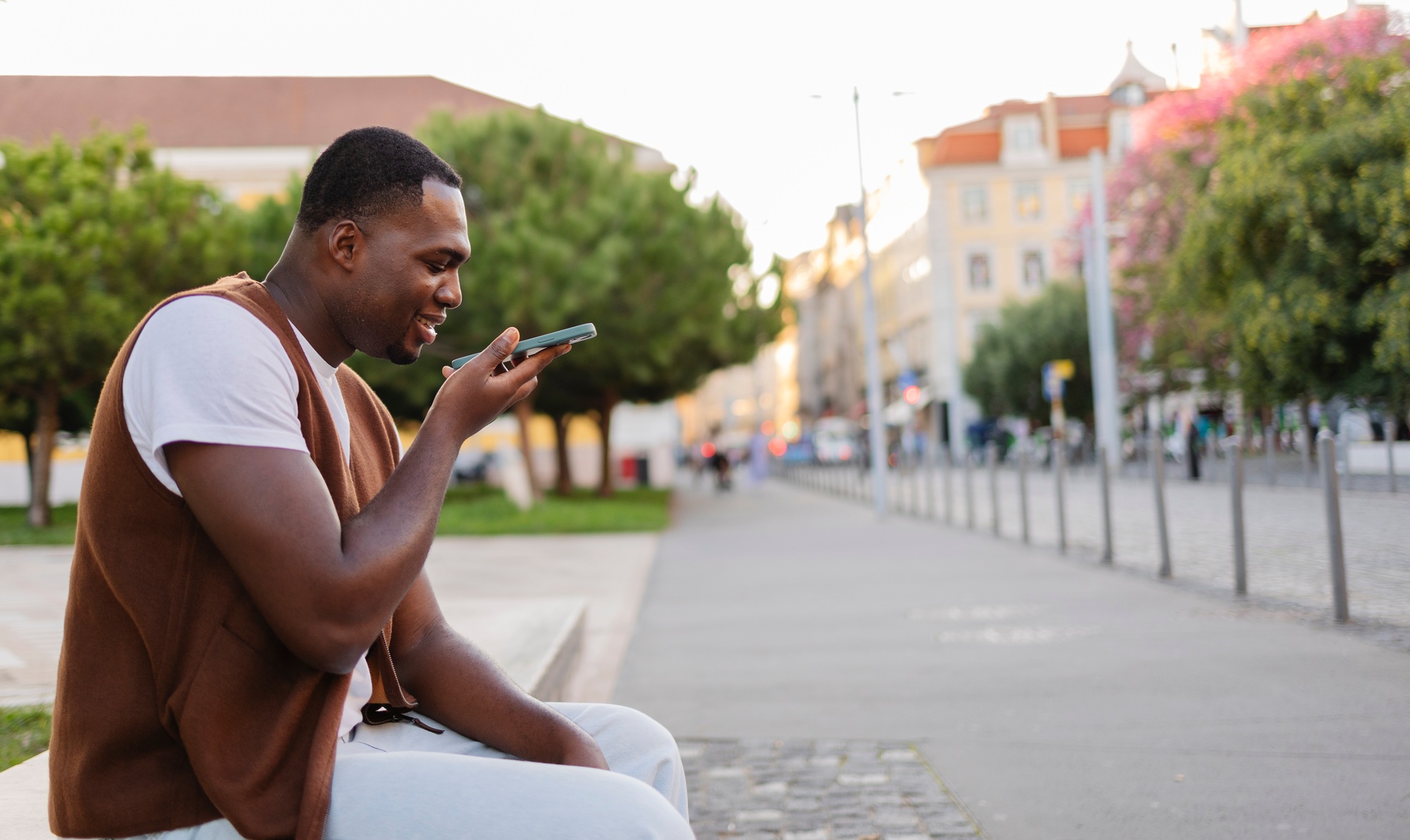 Young man sending a voice message in lisbon, portugal