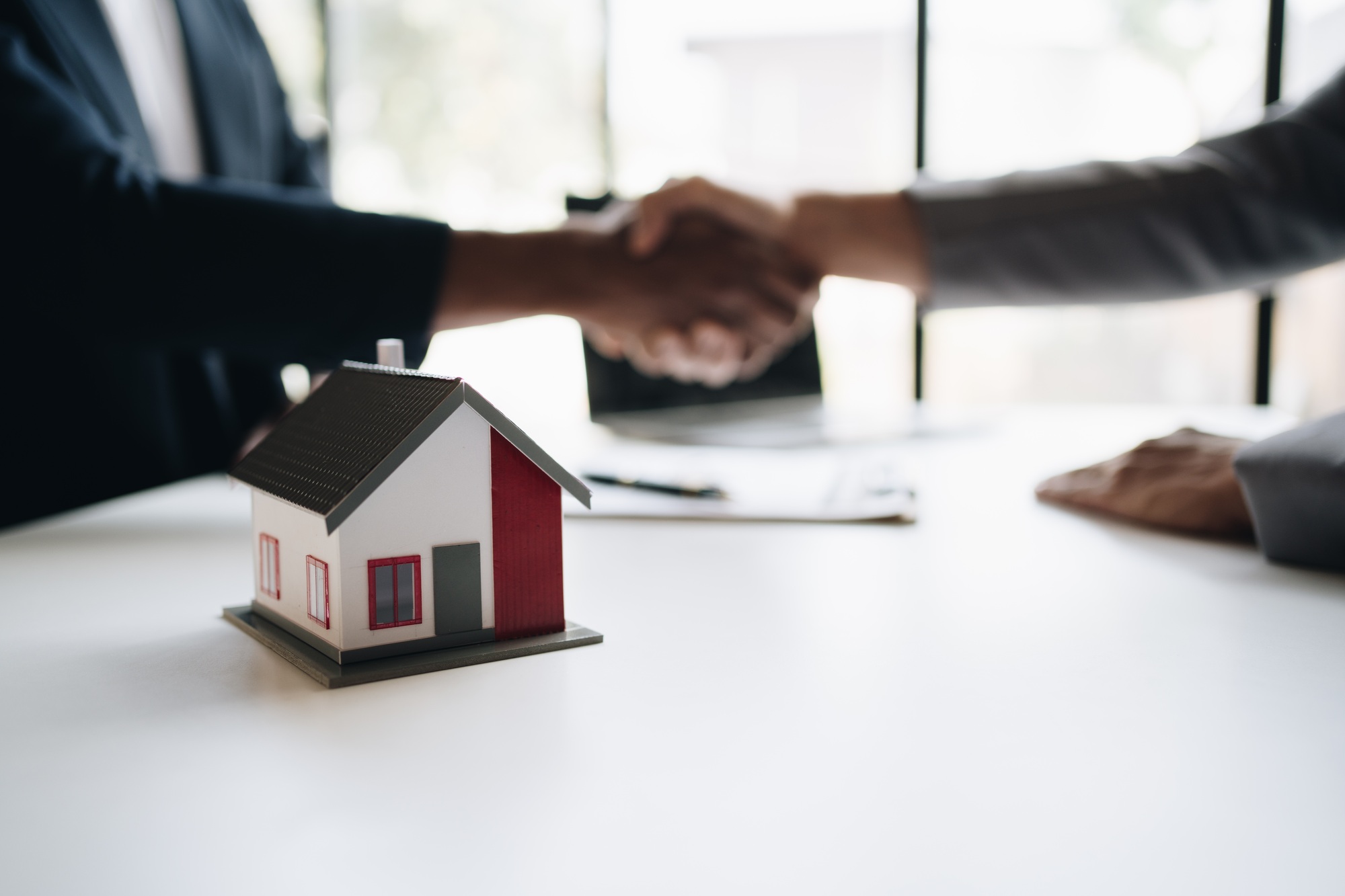 real estate broker manager hand shake to customer after signing contract for buying house.